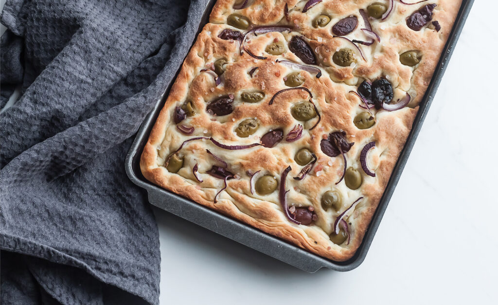 focaccia, wloski chlebek z oliwkami, czerwona cebula i sola